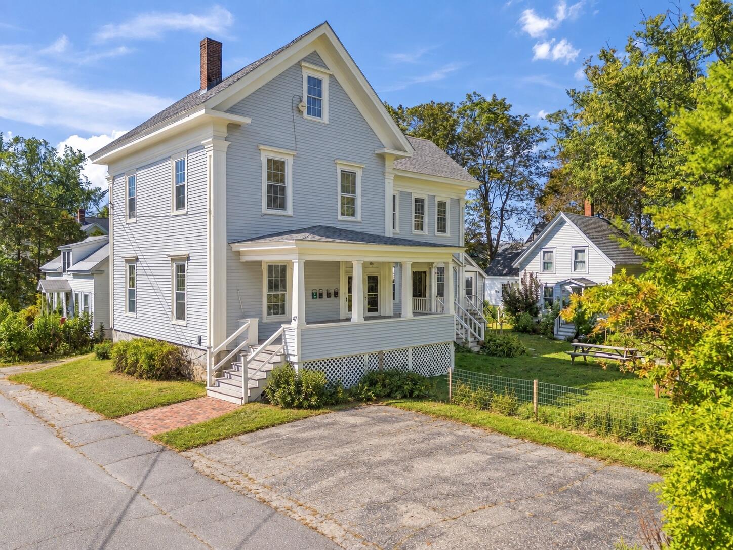 Light-blue two-story house with a covered porch and steep gabled roof at 45–47 Beacon Street.