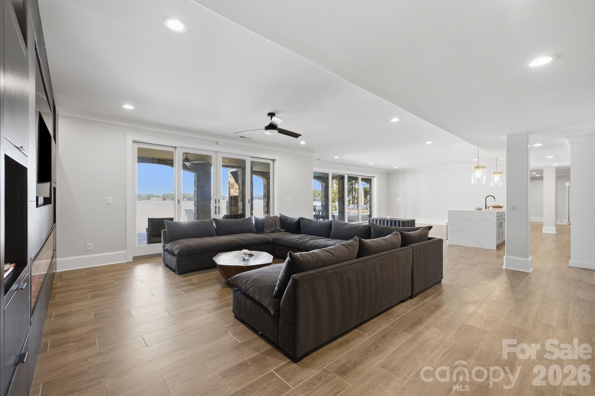 Open-plan living room with a dark sectional sofa and sliding doors overlooking the lake.