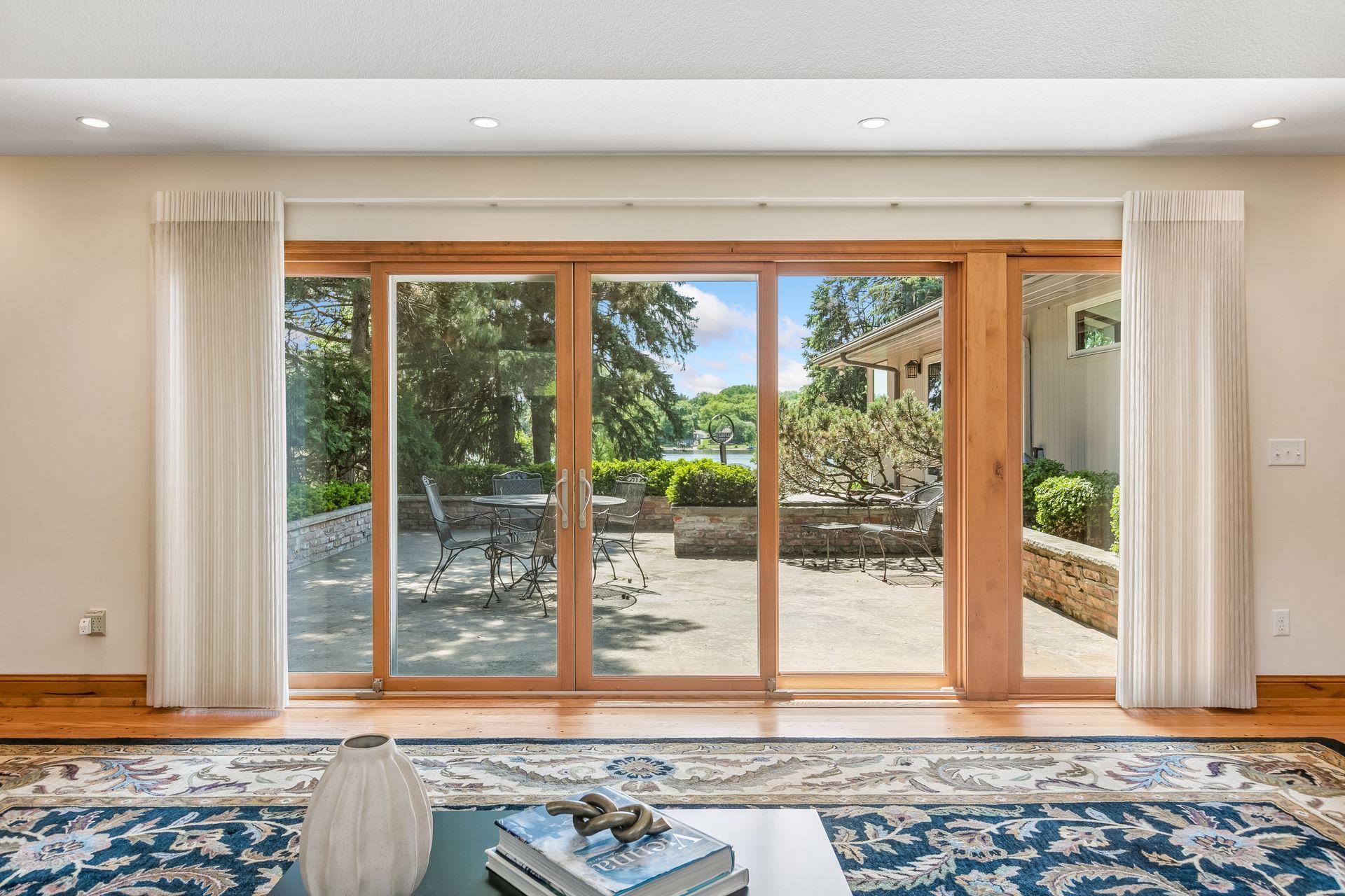 Living room with wood-framed sliding doors opening onto a patio overlooking the lake.