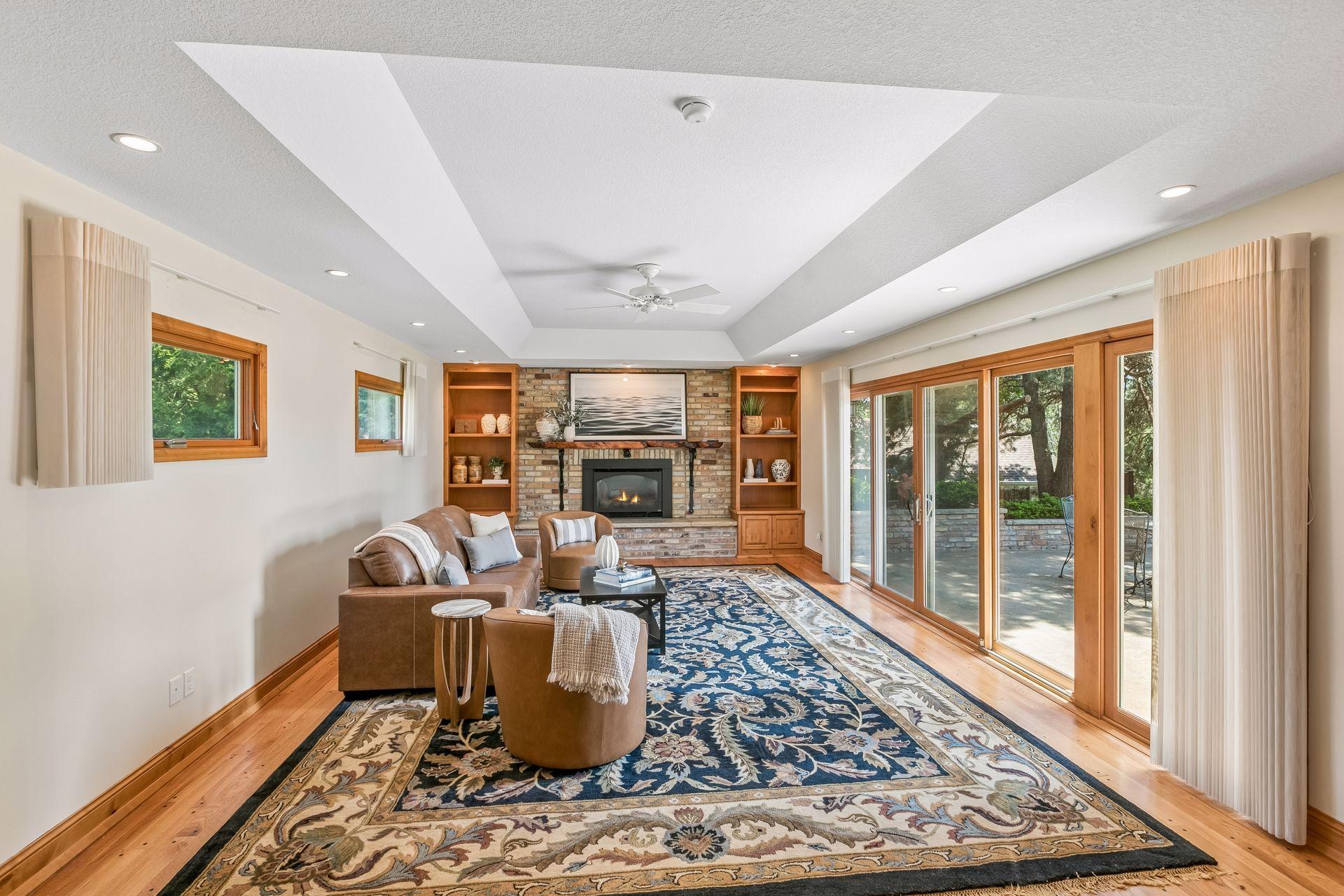 Living room with a brick fireplace, built-in shelves, and large sliding glass doors.