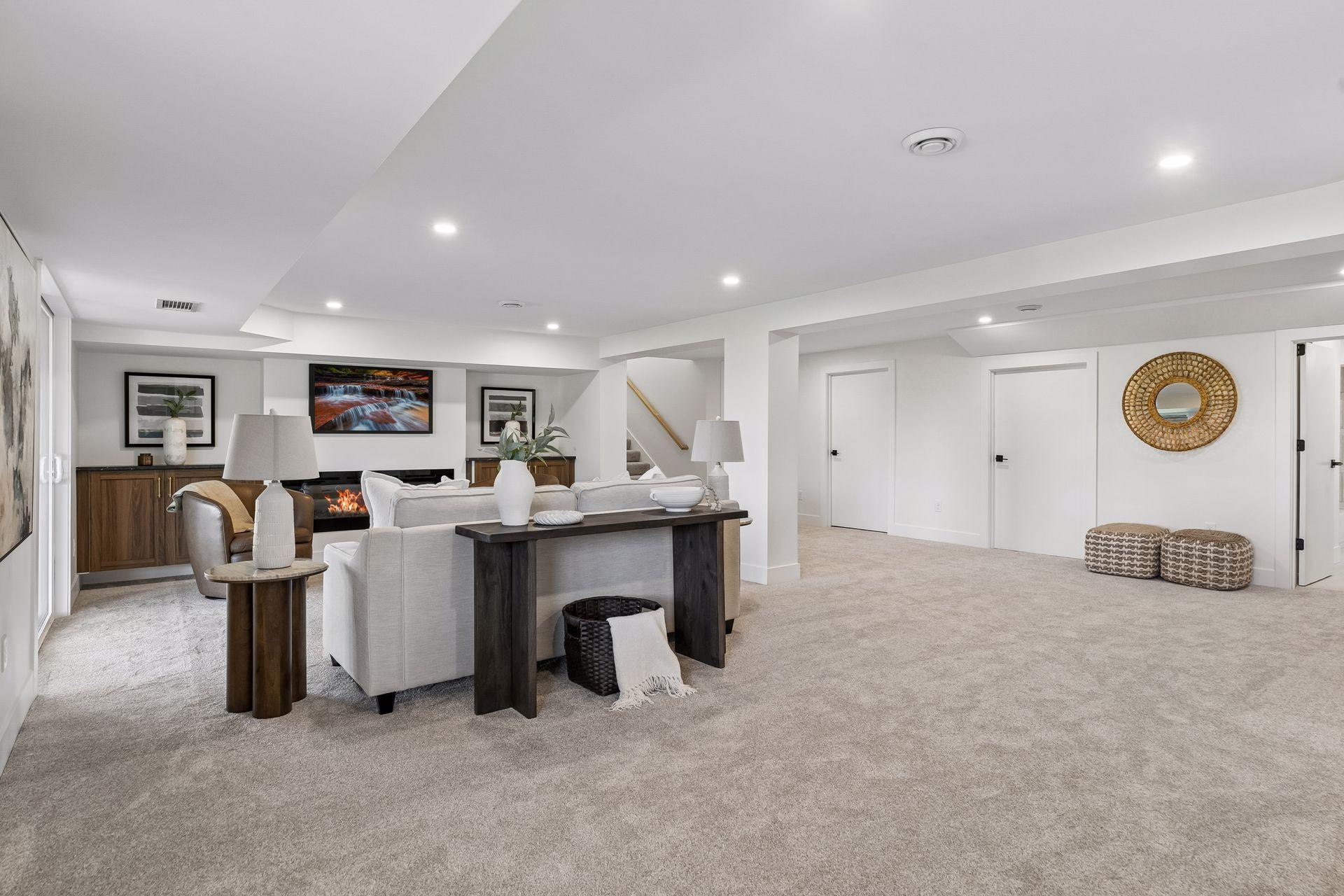 Staged family room with a light sectional, fireplace, walnut cabinetry, and spacious carpeted area.