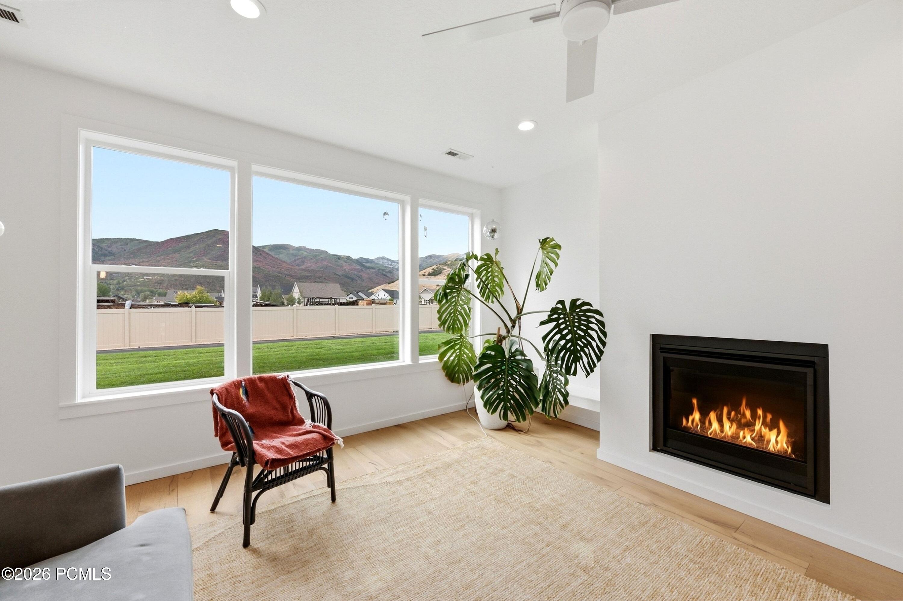 Living room with a linear fireplace and large windows framing a mountain view.