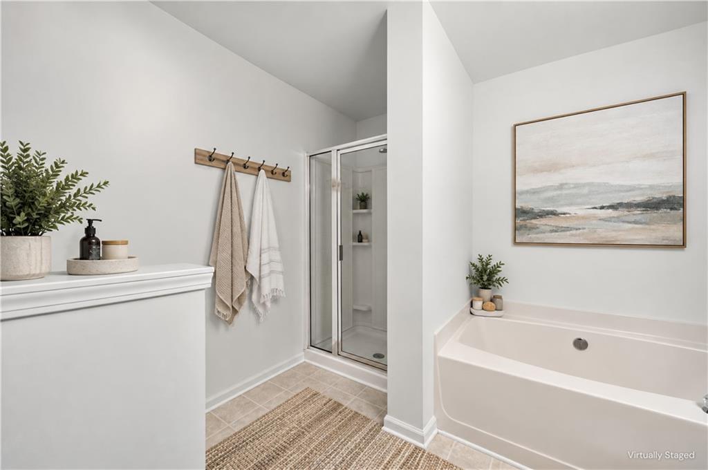 Staged bathroom with a glass shower and large soaking tub.