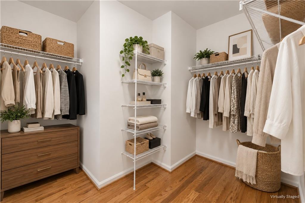 Walk-in closet with wire shelving, neutral clothing, baskets, and a wooden dresser.