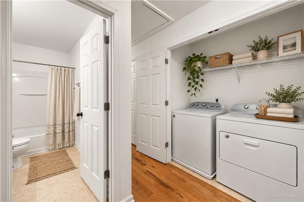 Laundry room with washer and dryer, open shelving, and a doorway to the adjoining bathroom.