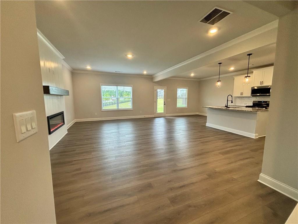 Open living room and kitchen with wood-look floors, a fireplace, and a breakfast bar.