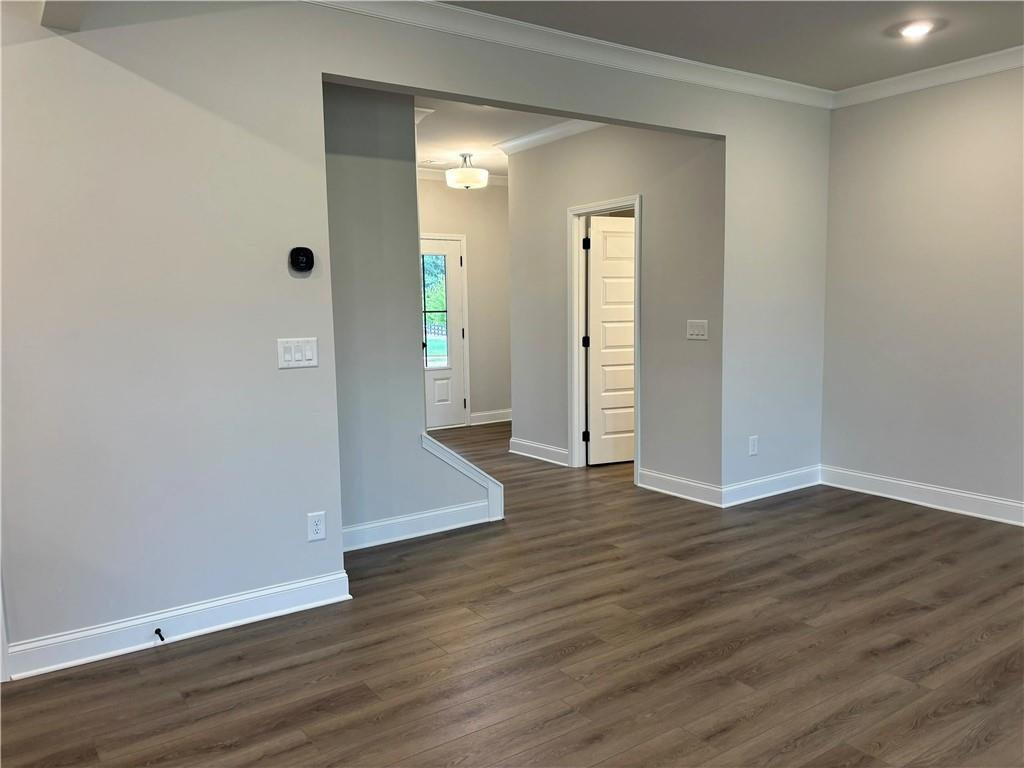 Vacant living room with wood-look flooring and an open entryway to the foyer.
