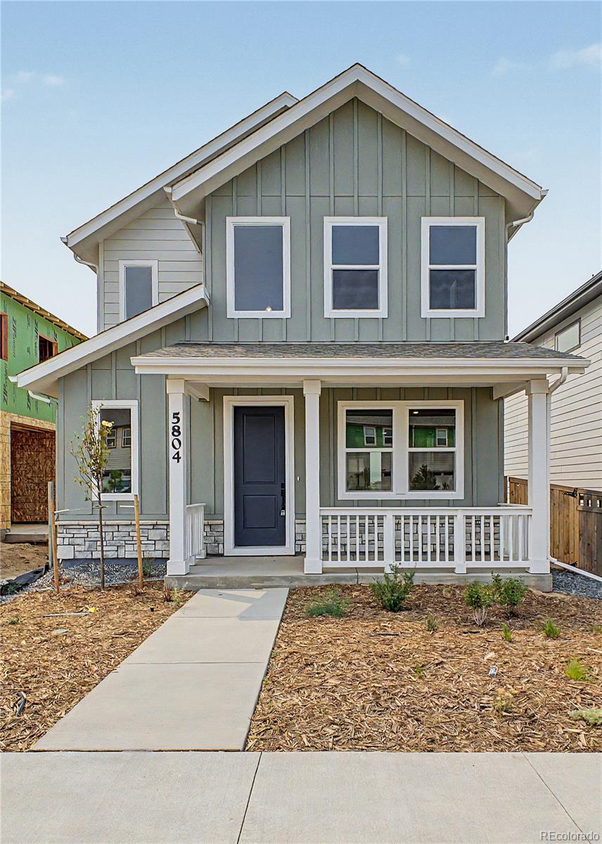 Gray two-story house with white trim, covered porch, and walkway to the front door.