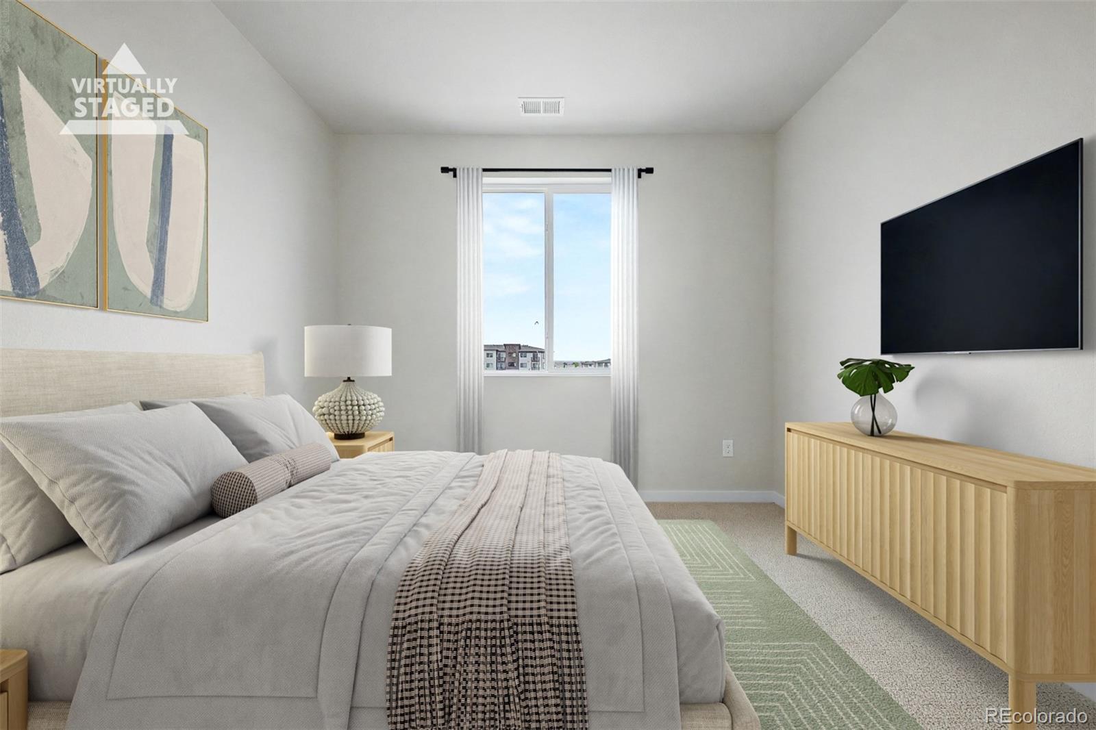 Virtually staged bedroom with a large bed, abstract art, window, wall-mounted television, and light wood dresser.