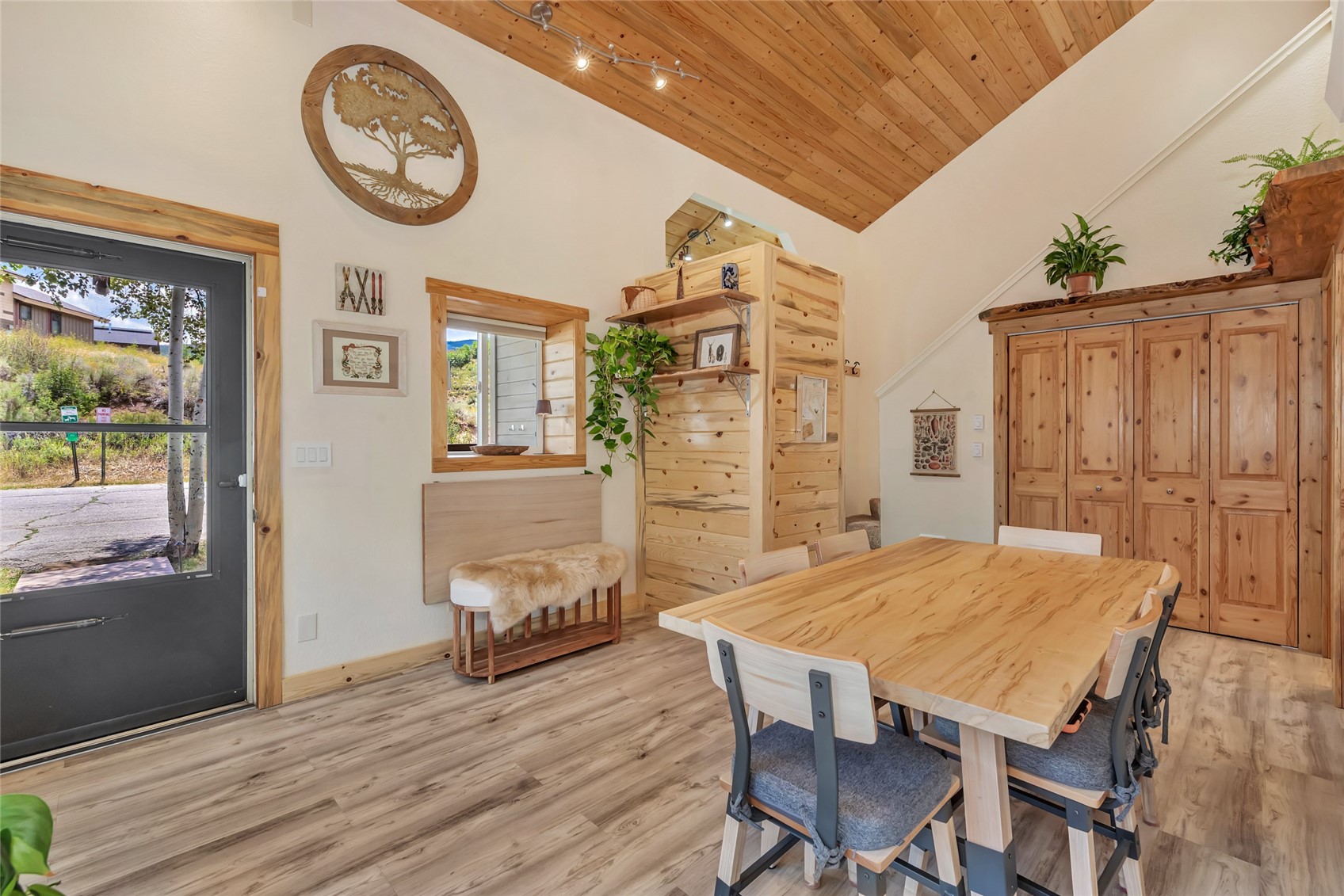Dining area with a vaulted wood ceiling, pine furnishings, and a large wooden table.