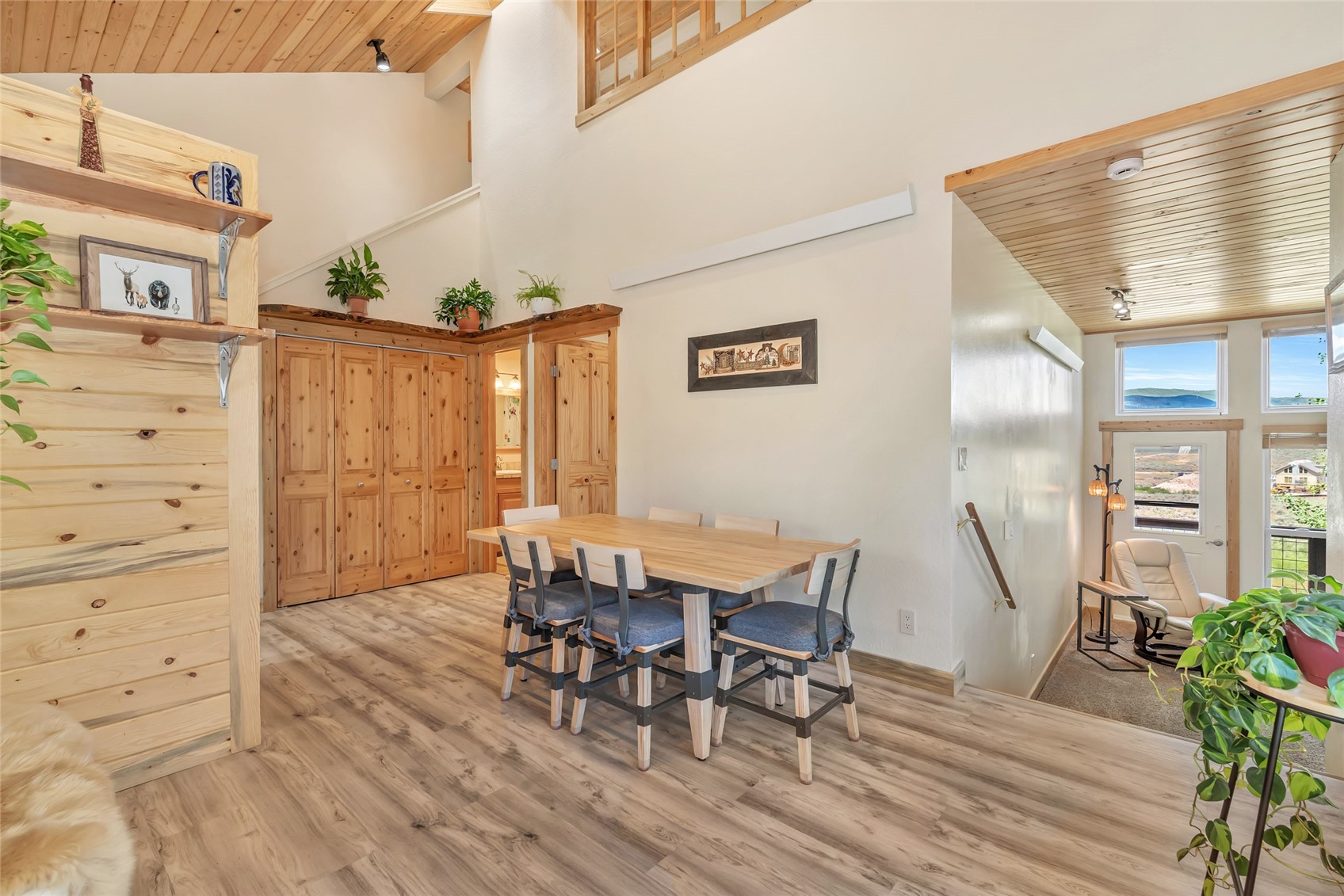 Dining area with pine cabinetry, a vaulted wood ceiling, and windows overlooking the landscape.