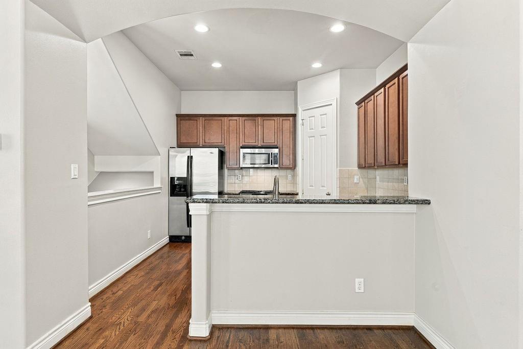 Kitchen with wood cabinets, stainless steel appliances, and a granite-topped peninsula.