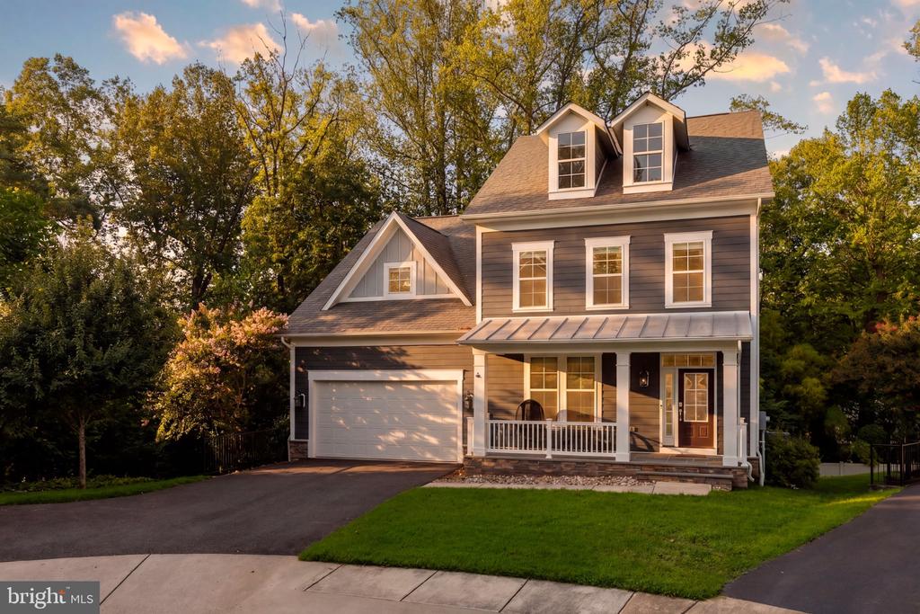 Gray two-story house with white trim, a two-car garage, and a covered front porch.