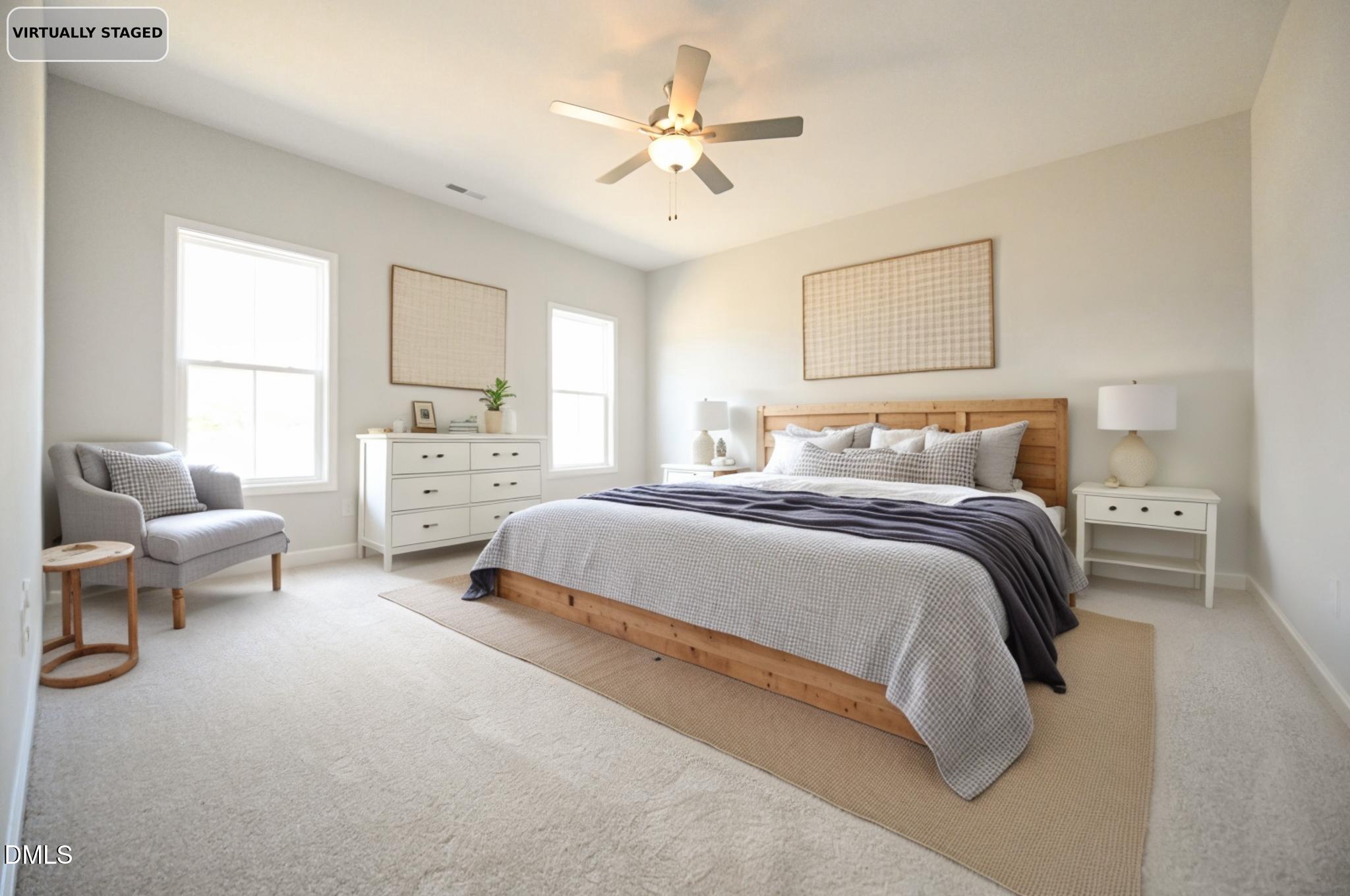 Virtually staged bedroom with a wood bed, gray bedding, white furniture, and a chair by two windows.