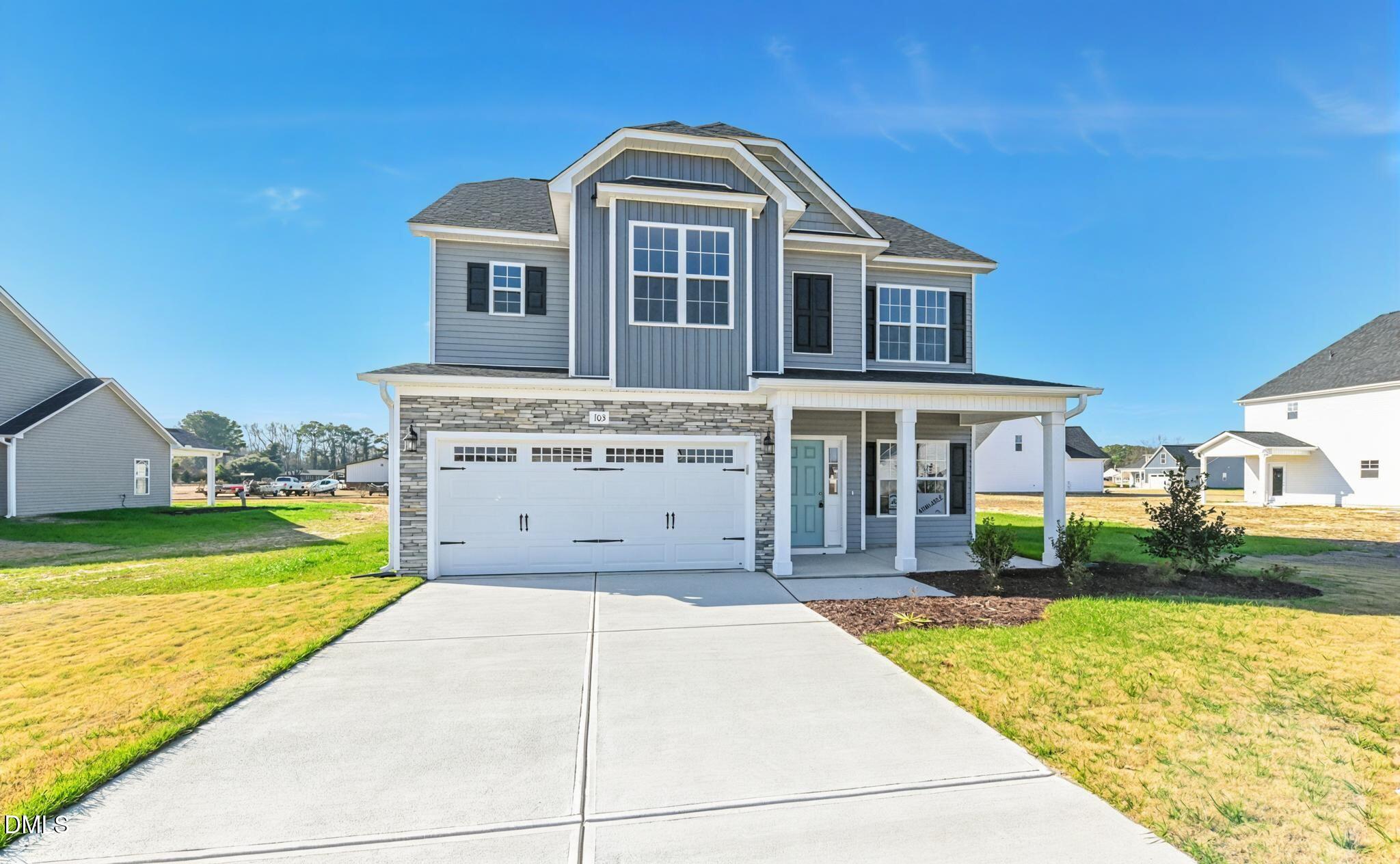 Two-story gray home with a stone-accented facade, two-car garage, and covered front porch.