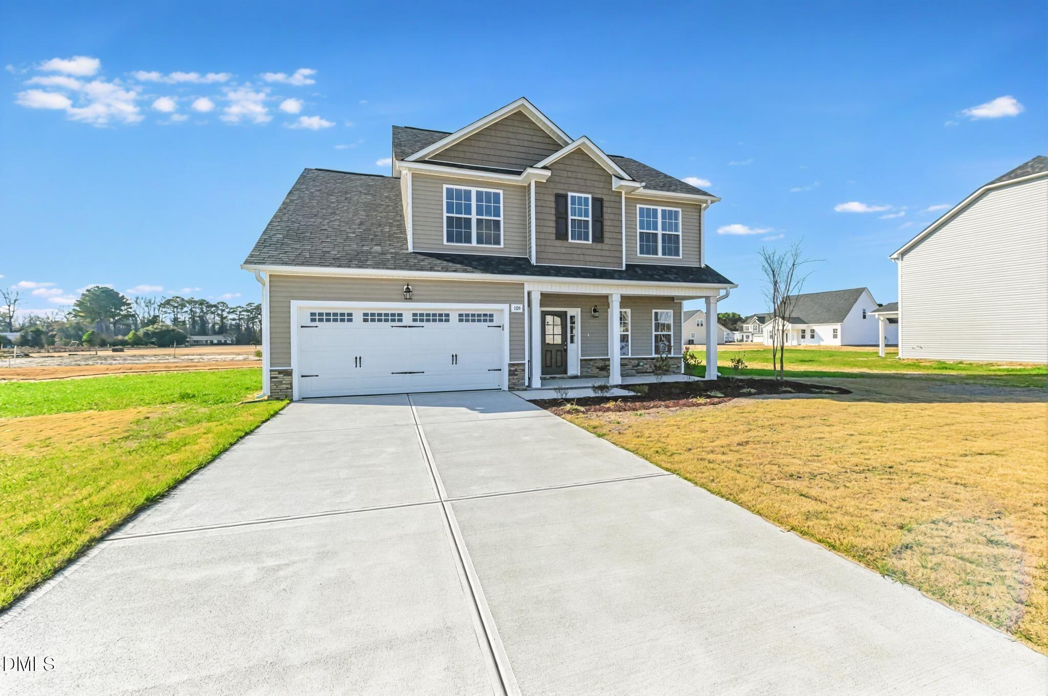 Two-story home with a two-car garage, covered porch, and wide concrete driveway.