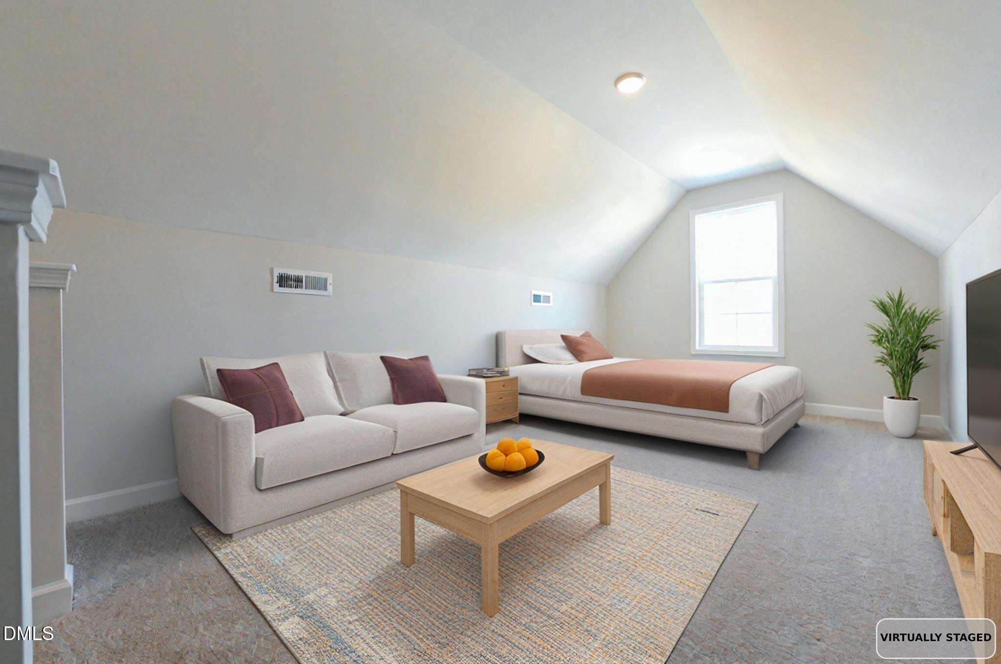 Attic bedroom with vaulted ceiling, a bed, and a light sofa beside a tall window.