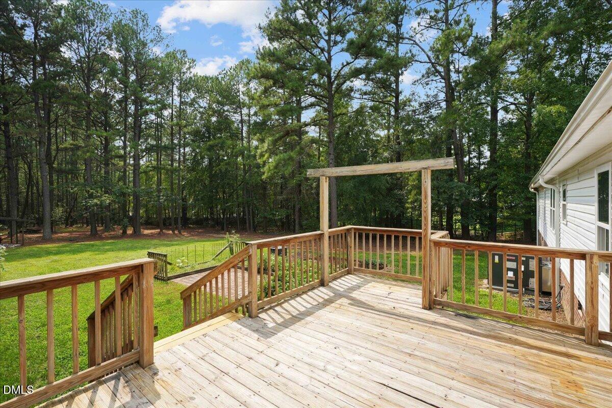 Wooden deck overlooking a lawn and wooded backyard