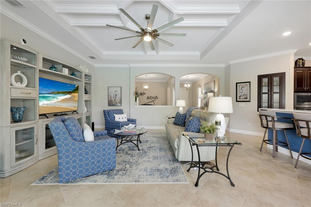 Living room with blue patterned armchairs, a white sofa, and a coffered ceiling.