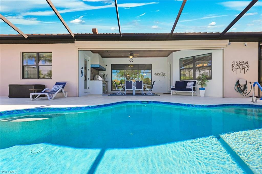 Backyard pool and covered lanai with outdoor dining, seating, and a screened enclosure.