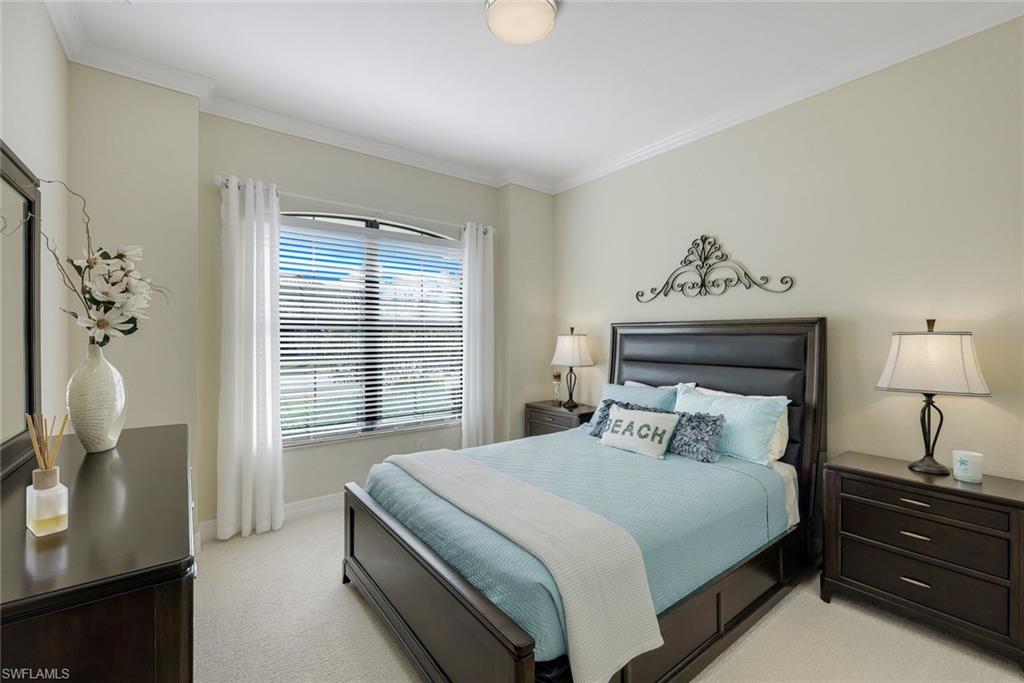Bedroom with pale aqua bedding, dark wood furniture, and a window with white blinds.