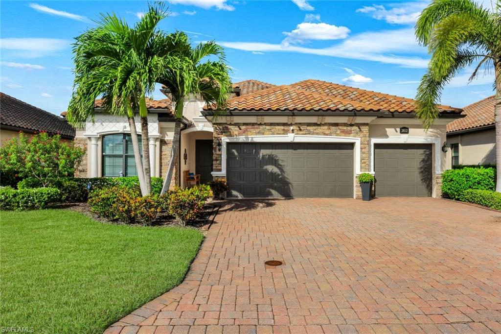 Single-story home with a stone-accented facade, terracotta roof, and palm-lined brick driveway.