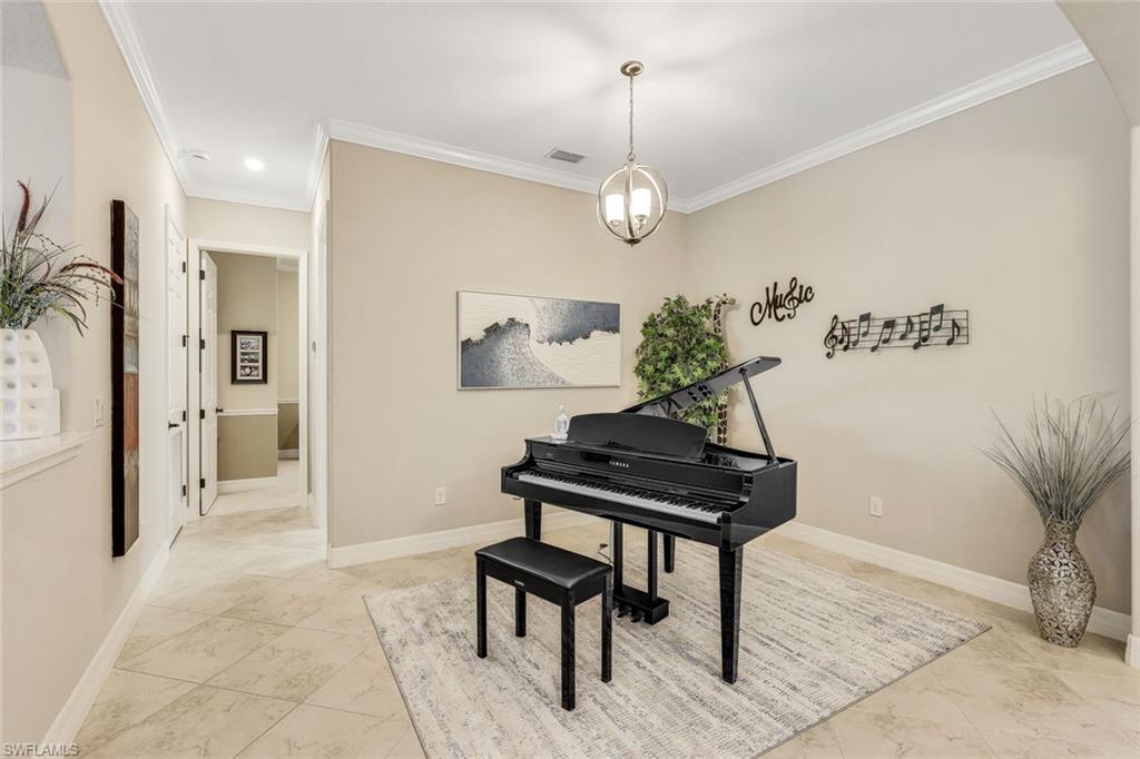 Music room with a black grand piano, music-themed wall décor, and a light area rug.