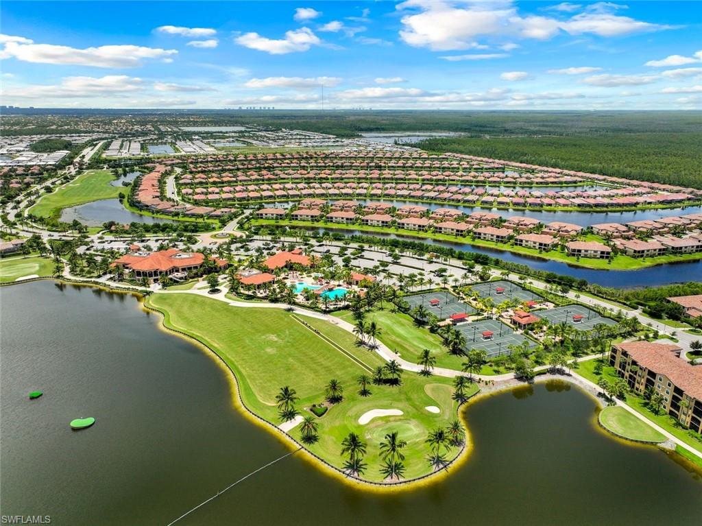 Aerial view of a residential community with golf course, lakes, tennis courts, and pool.