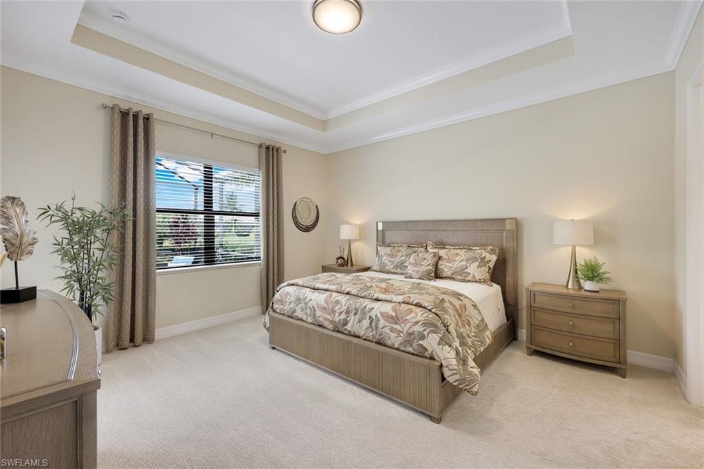 Staged bedroom with floral bedding, a king-size bed, and a tray ceiling.