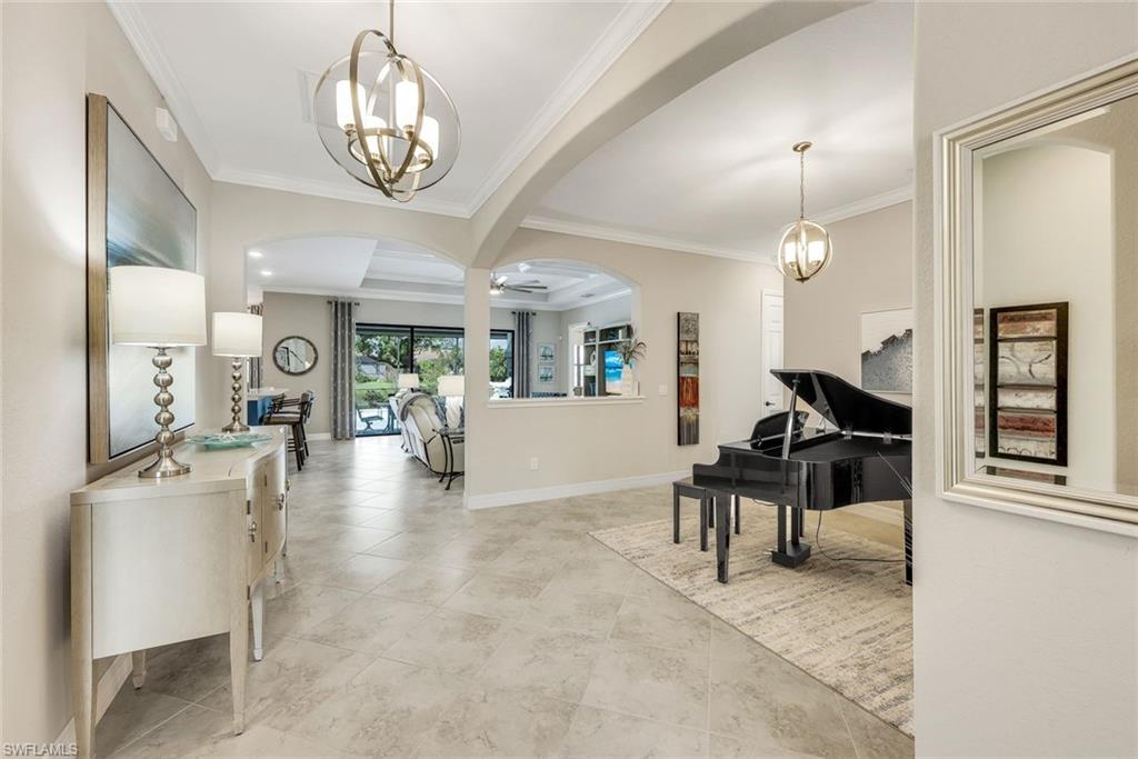 Open-plan living room with a black grand piano, arched openings, and sliding glass doors to the garden.