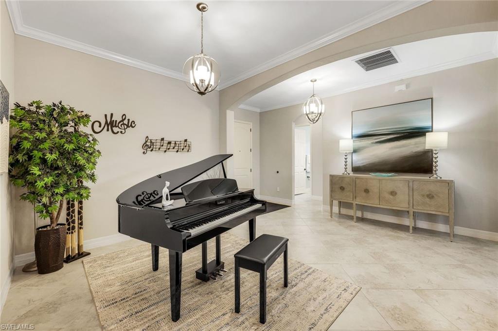 Furnished music room with a black grand piano, patterned rug, and music-themed wall decor.