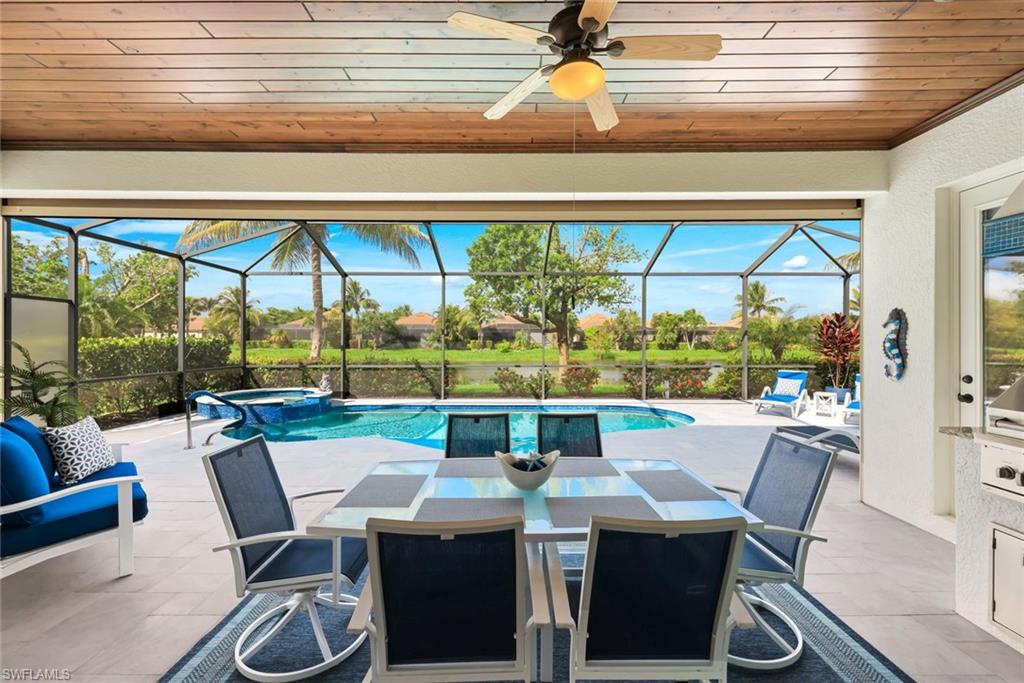 Screened lanai with outdoor dining furniture, a swimming pool, and a lake view.