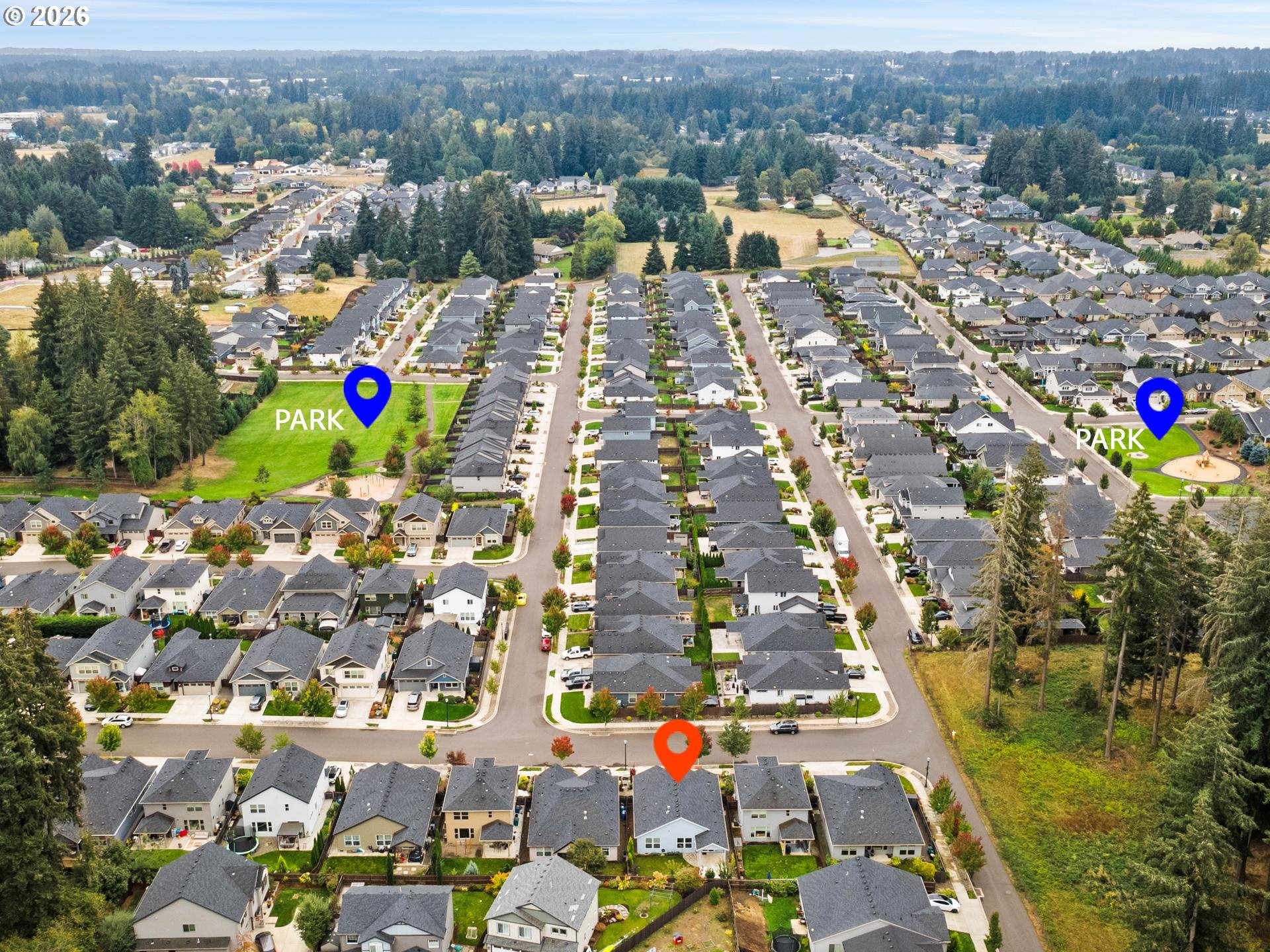 Aerial neighborhood view with an orange pin marking a home and blue pins marking two parks.