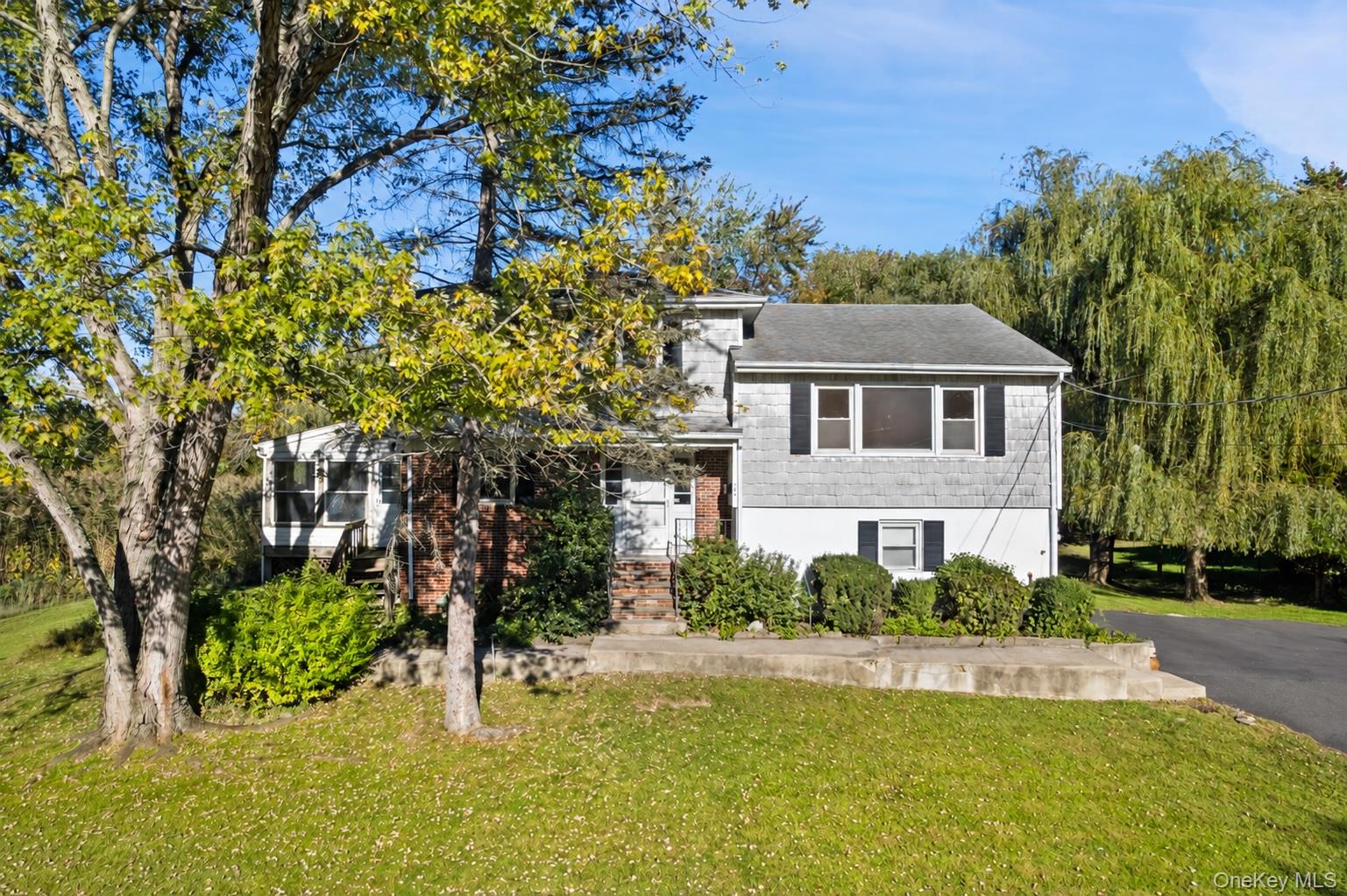 House at 180 Bradford Avenue with gray siding, brick entry, and landscaped front yard.