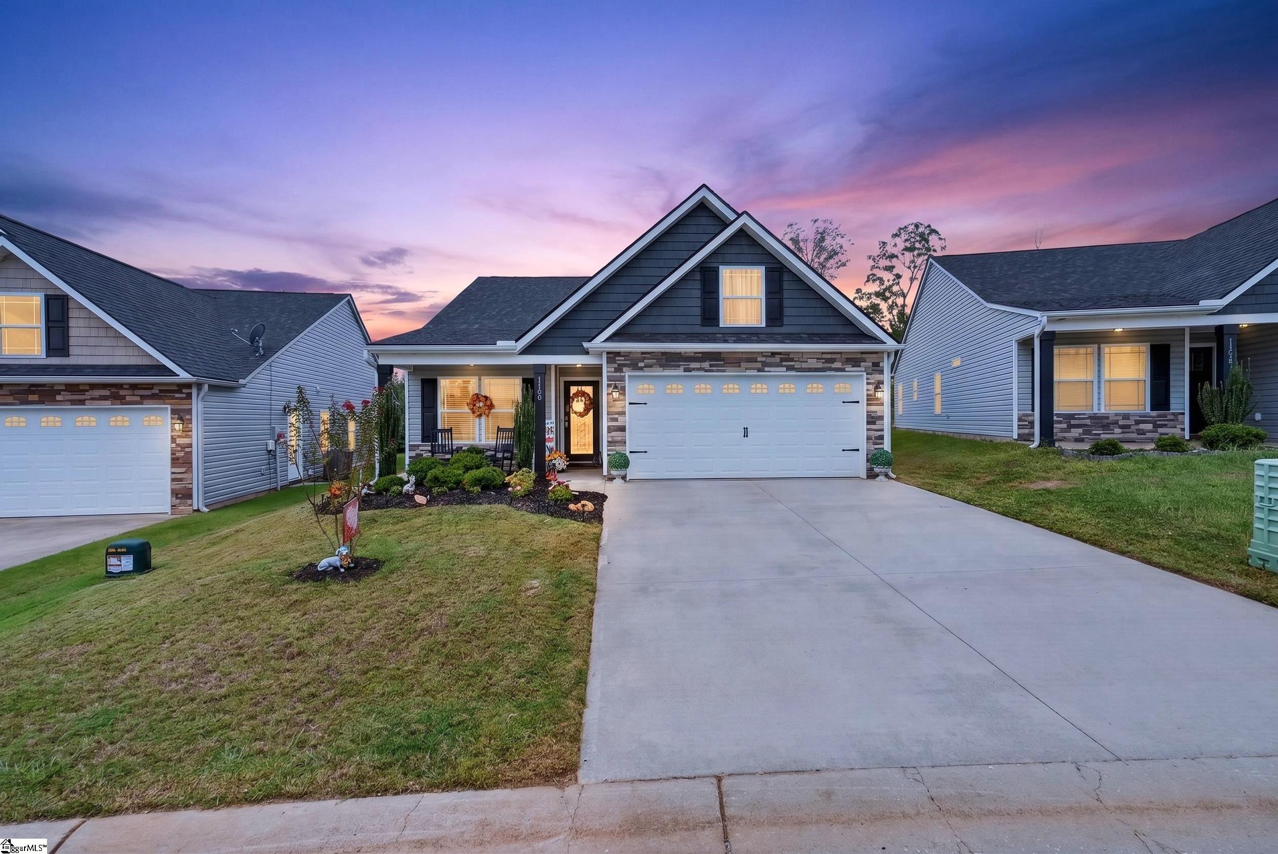 Two-story home with a double garage and broad driveway at dusk.