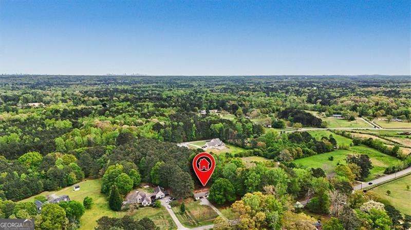 Aerial view of 1361 Villa Rica Road, marked among wooded land, neighboring homes, and open fields.