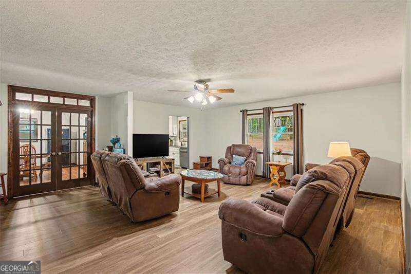 Living room with brown recliners, French doors, and wood-look flooring.
