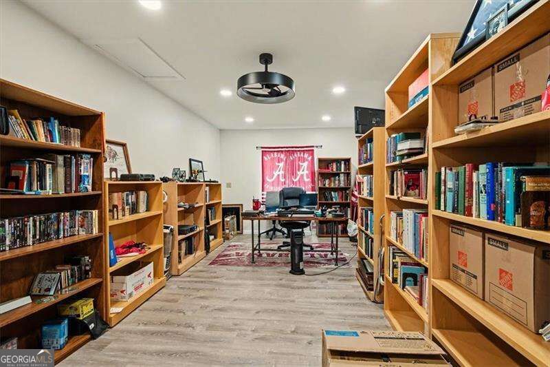 Library with wooden bookshelves, a desk, and a red banner behind the desk.