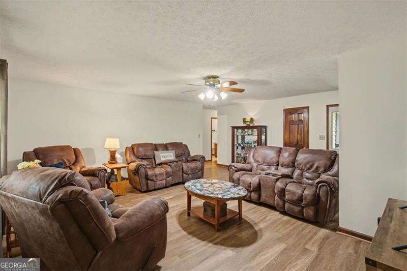 Living room with brown leather recliners, a marble-top coffee table, and wood-look flooring.