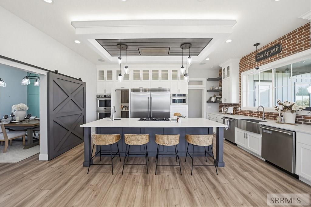 White kitchen with large granite island and suspended seating, riverfront home Shelley Idaho
