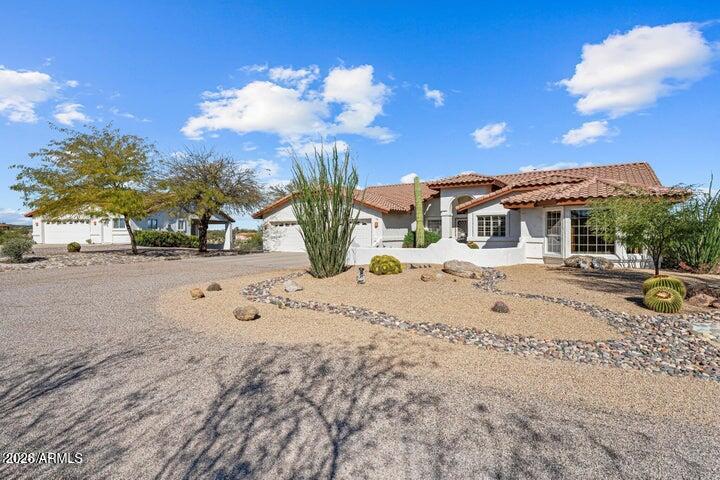 Single-story stucco home with a red tile roof and desert landscaping.