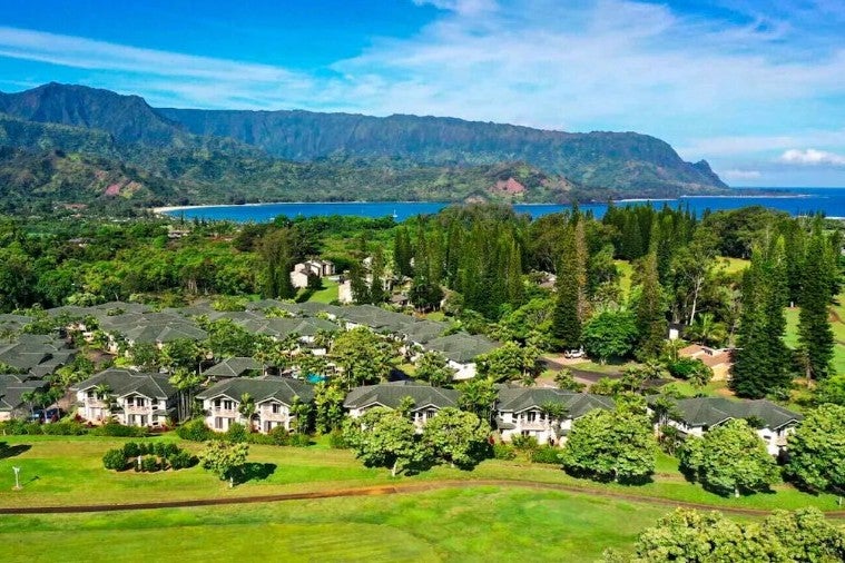 Aerial view of homes with ocean and mountain views on Kauai.