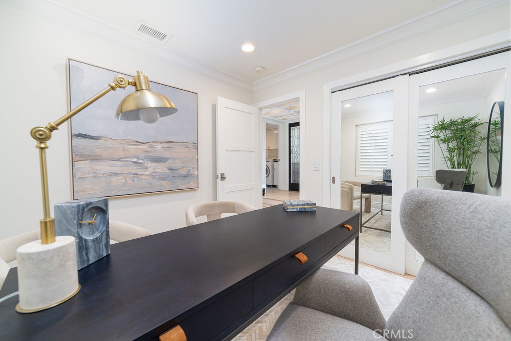 Home office with a long dark desk, brass lamp, and mirrored sliding doors.