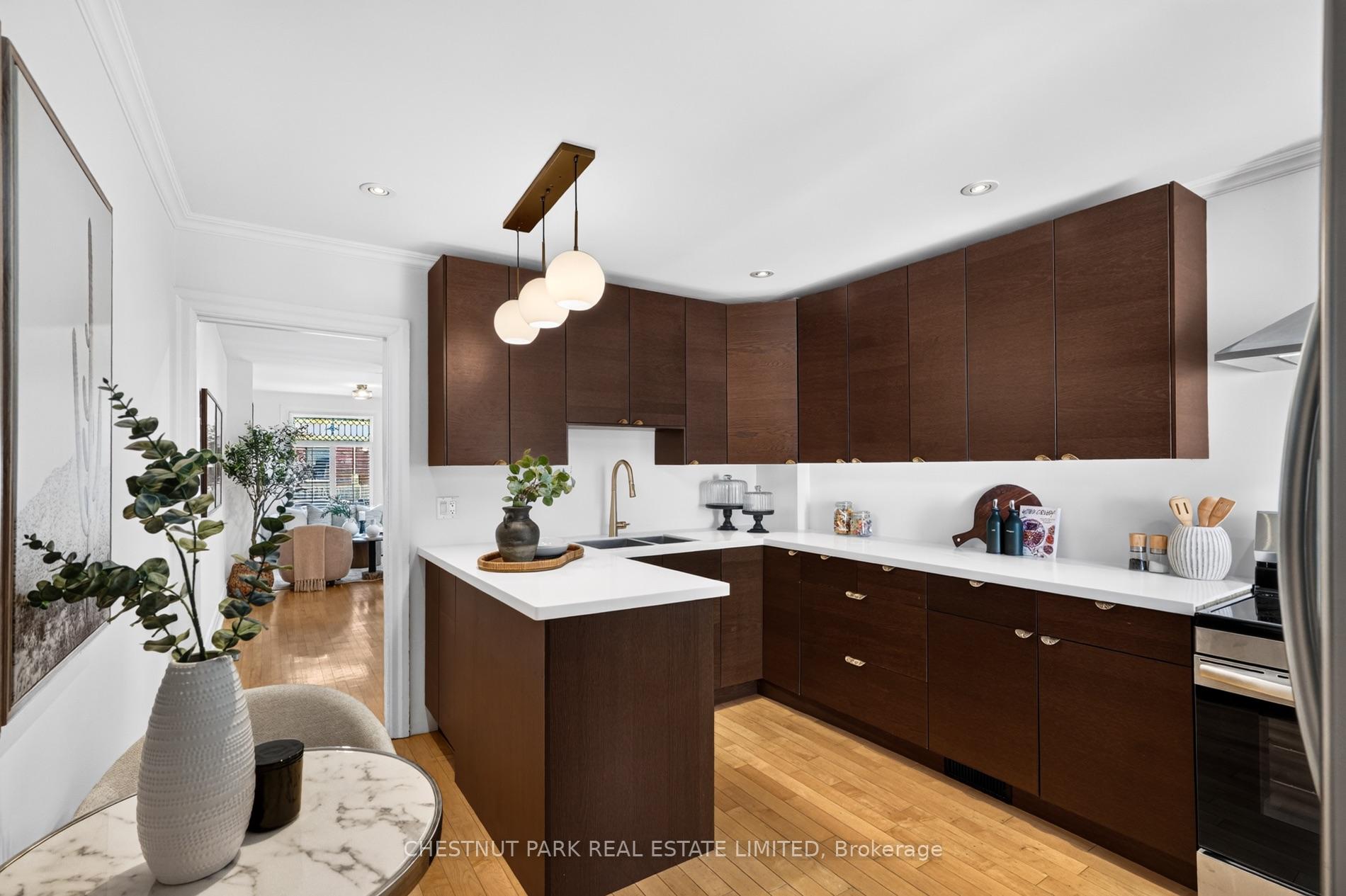 Modern kitchen with dark wood cabinets, white countertops, and a peninsula island.