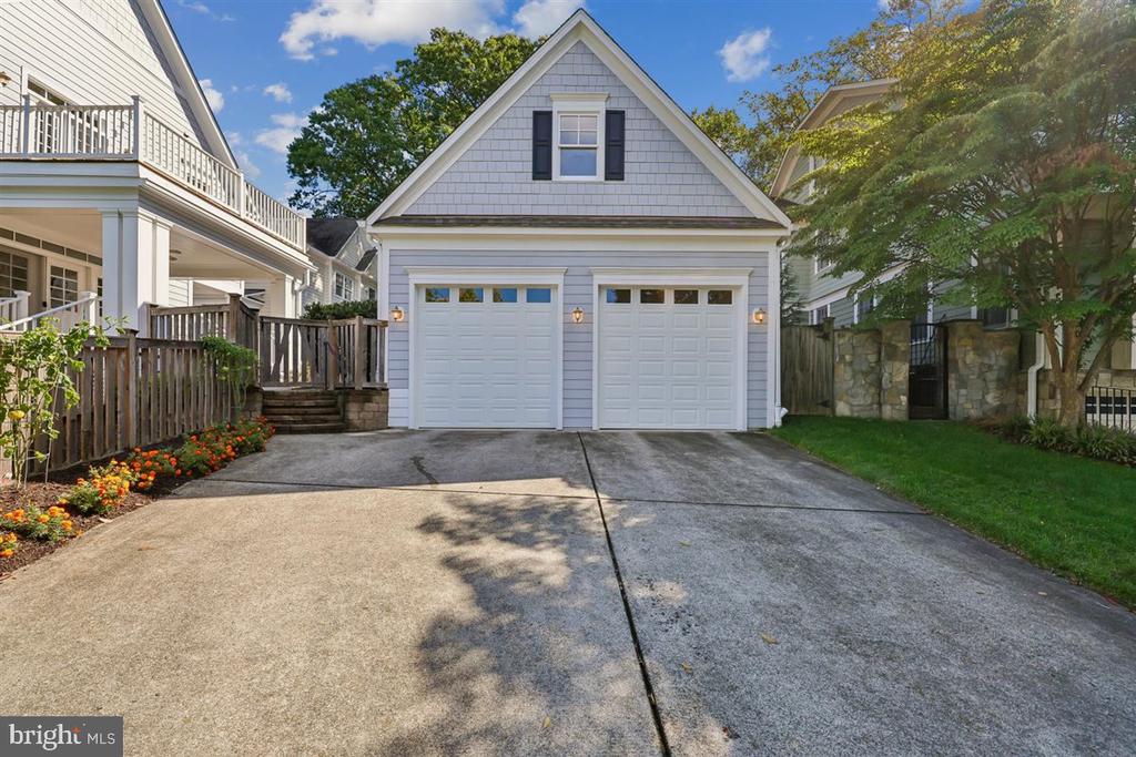 White two-car garage with a steep gabled roof and broad concrete driveway.