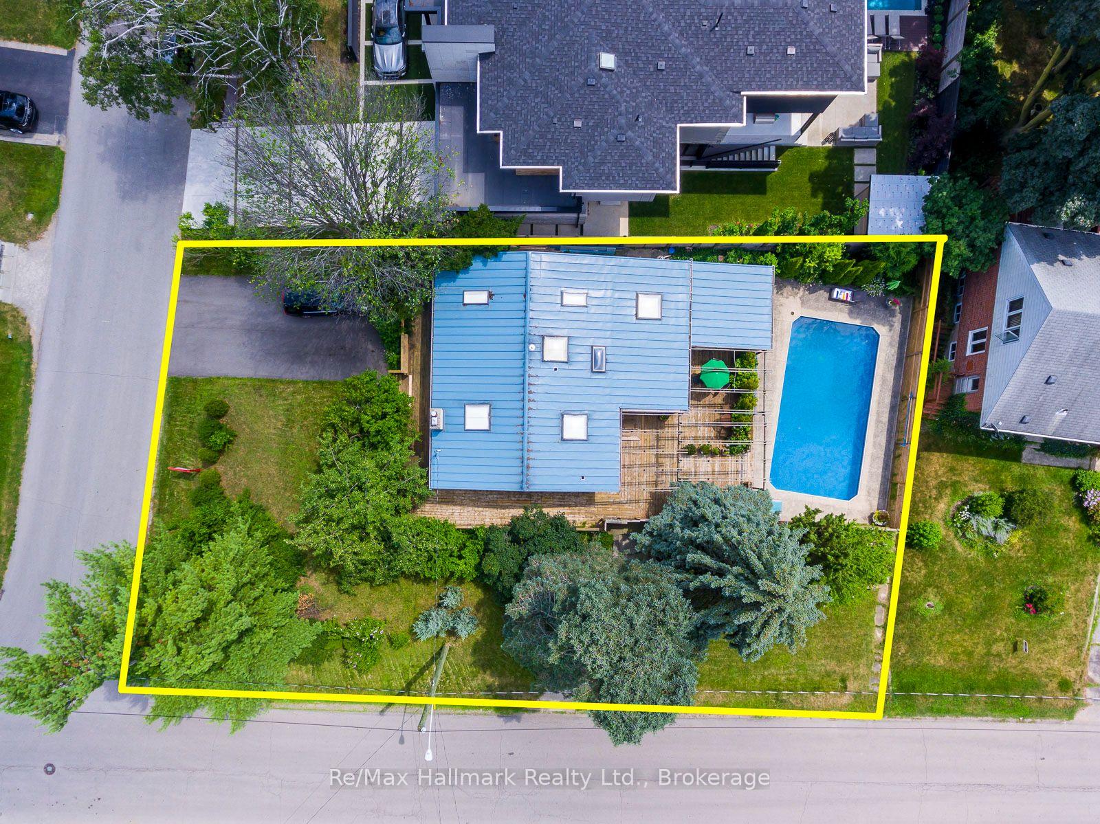 Aerial view of the property, outlined in yellow, with a swimming pool and landscaped yard.