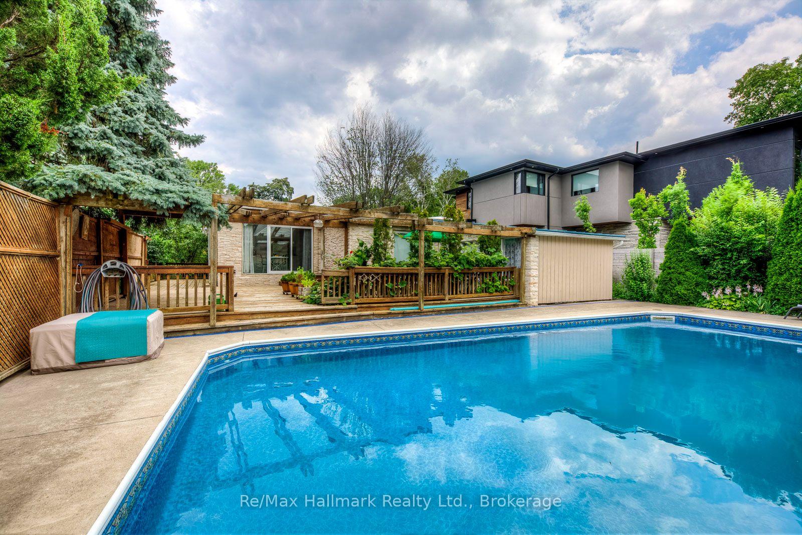 Backyard swimming pool beside a stone-clad patio and pergola at 1510 Constance Drive.