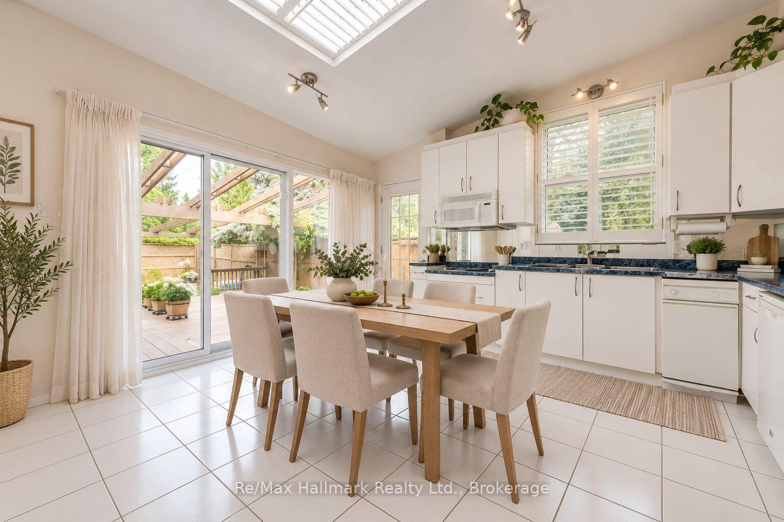 Bright kitchen and dining area with a skylight and sliding doors to the patio.