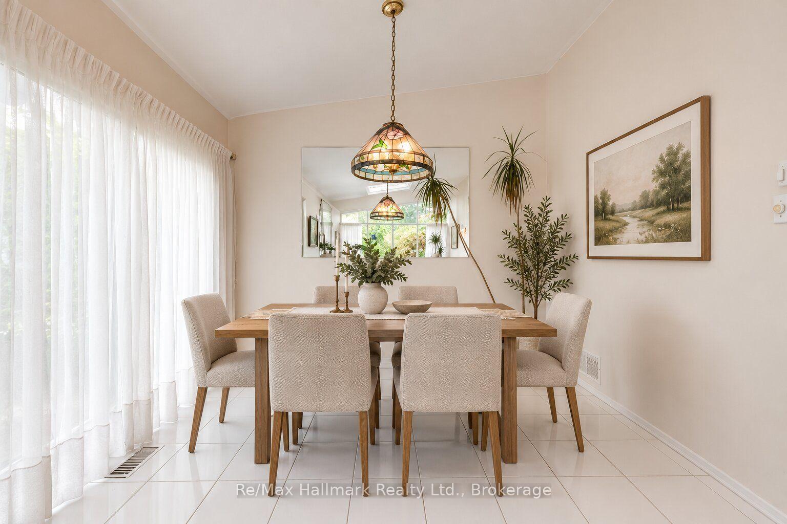 Dining room with a wooden table, upholstered chairs, stained-glass pendant light, and sheer-curtained windows.