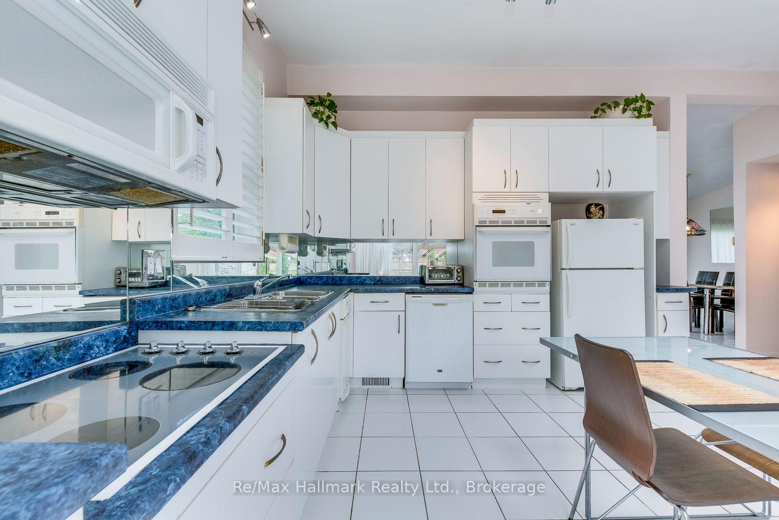 Bright kitchen with white cabinets, blue countertops, and a breakfast table.